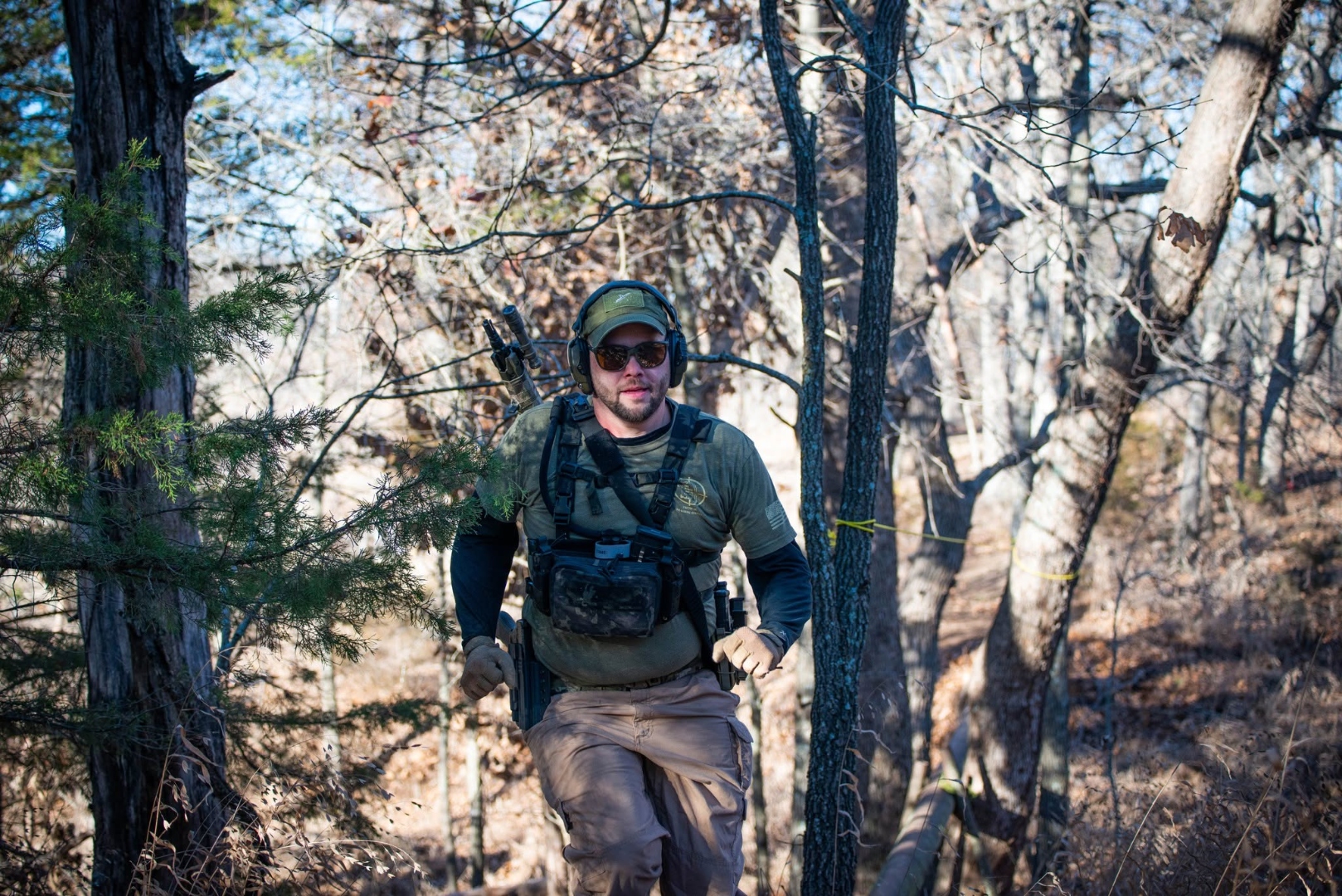Competitor running through wooded natural terrain at The Burial Mound